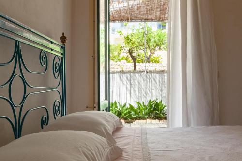 Villa Aimone في مارينا بورتو: غرفة نوم بسرير ونافذة كبيرة