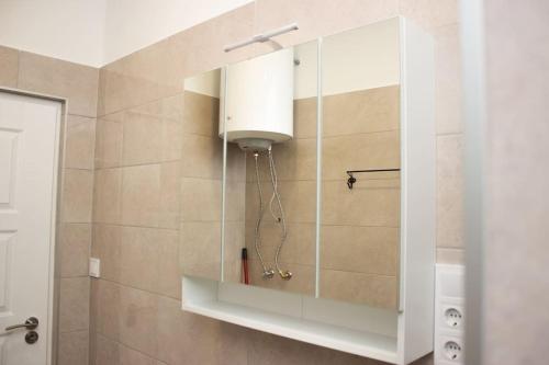 baño con ducha y armario blanco en Broadway Apartments B1 en Debrecen