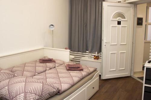 een slaapkamer met een bed en een witte deur bij Broadway Apartments B1 in Debrecen