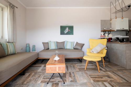 a living room with a couch and a table and a chair at ALMA HILLS Gialova in Gialova