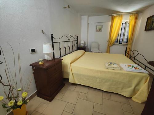 a bedroom with a bed and a table with a lamp at VILLA CHARME in Scalea