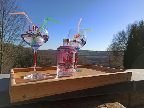 two wine glasses and a bottle on a wooden tray at TERRASSES DE MALMEDY Triplex 262 SWEET HOME in Malmedy