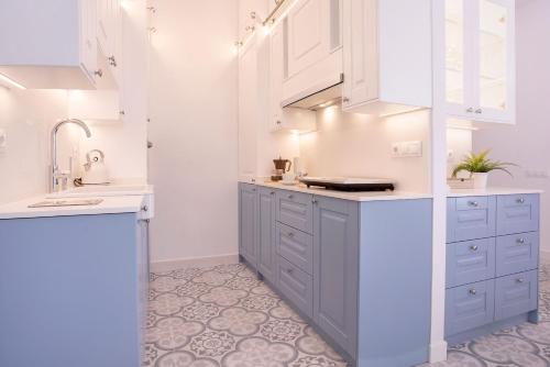 una cocina con armarios azules y fregadero en Genteel Home Marín García, en Málaga