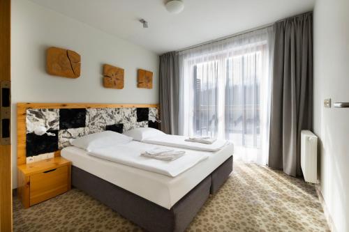 a bedroom with a bed and a large window at VacationClub – Cristal Resort Apartament 222 in Szklarska Poręba