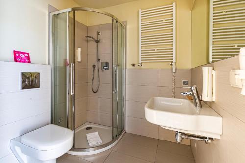 a bathroom with a shower and a toilet and a sink at VacationClub – Cristal Resort Apartament 222 in Szklarska Poręba