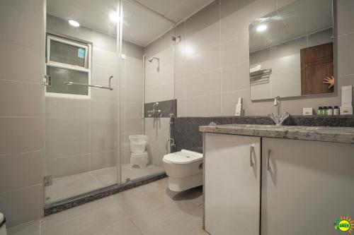 y baño con aseo, ducha y lavamanos. en SUMMER GREEN RESORT en Secunderābād