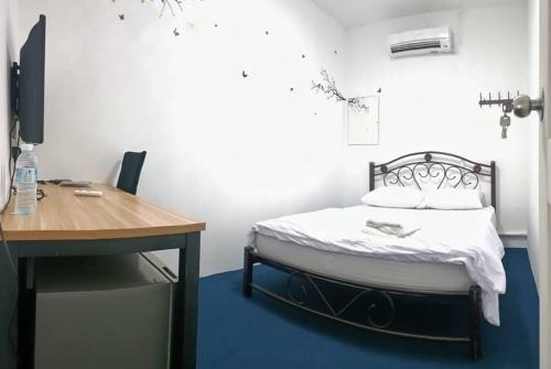 - une petite chambre avec un lit et un bureau dans l'établissement 246housecafe, à George Town
