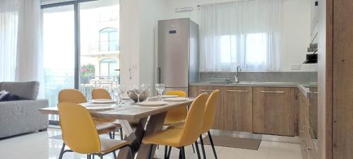 a kitchen with a dining table and yellow chairs at Bright Stylish Apartment in Victoria