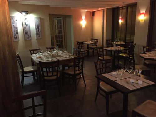 ein Restaurant mit Tischen und Stühlen in einem Zimmer in der Unterkunft Le Petit Keriquel in La Chapelle-Caro