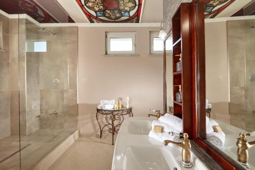 a bathroom with a sink and a shower and a mirror at Karavla Private Villa in Šentilj