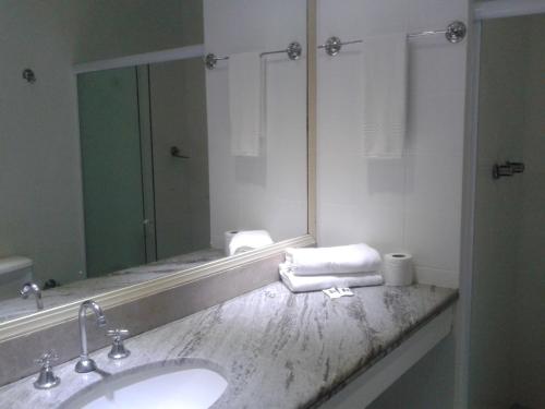 a bathroom with a sink and a large mirror at MK Express Hotel in Aracaju