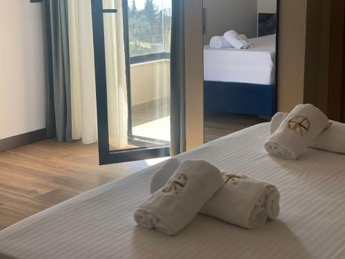 a hotel room with towels on a bed with a mirror at Gogo's Boutique Hotel in Dhërmi