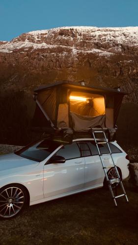 a white car with a tent on top of it at Rent Rooftop tent for car with roofrack in Stavanger