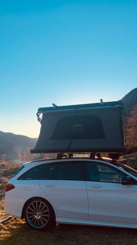 a white car with a roof rack on top of it at Rent Rooftop tent for car with roofrack in Stavanger