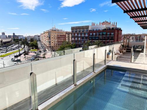 Valencia Luxury - Calma Beach Apartments في فالنسيا: اطلالة من سطح مبنى مع مسبح