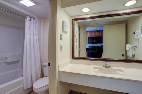 ein Badezimmer mit einem Waschbecken, einem WC und einem Spiegel in der Unterkunft Landmark Resort 936 in Myrtle Beach