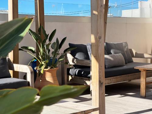 a patio with a couch and a table and plants at Valencia Luxury - Calma Beach Apartments in Valencia