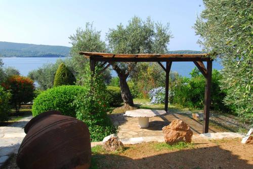 a gazebo with a large wooden object in a garden at Saint Andrews Bay in Milína