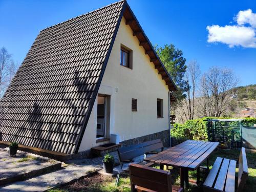 a house with a metal roof and a picnic table at Can Nitu in Camprodon