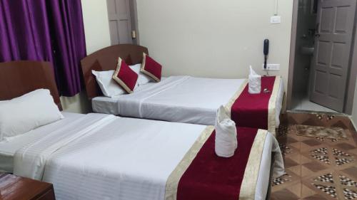 una habitación de hotel con dos camas y una mesa en Magvaris Comfort Inn, en Shillong
