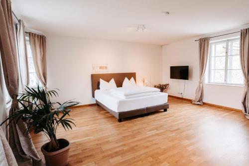 ein Schlafzimmer mit einem weißen Bett und einer Topfpflanze in der Unterkunft Kaiser's Hof in Strass