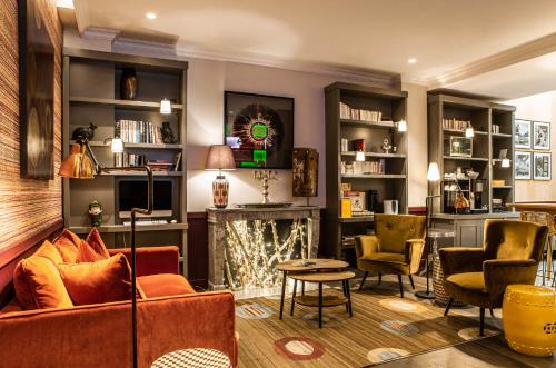 a living room with a couch and a fireplace at Hôtel Adèle & Jules in Paris