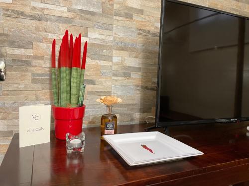 a desk with a laptop and a vase with red candles at Villa Carly Taormina apartment with private pool in Trappitello