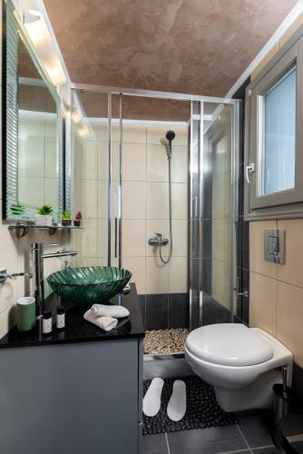 a bathroom with a sink and a toilet and a shower at Horizon Sky House with view in Pyrgos
