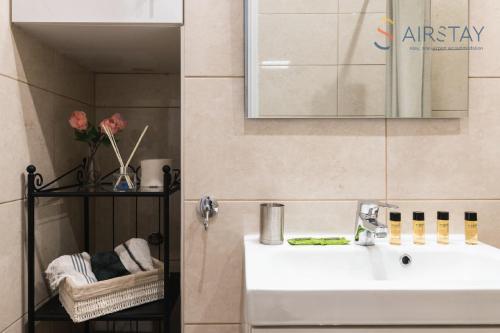 a bathroom with a white sink and a mirror at Anivia Apartments Airport by Airstay in Spata