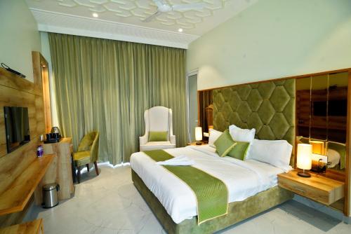 een hotelkamer met een groot bed en een televisie bij 5 States Resort in Amritsar