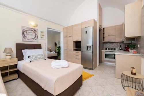 a bedroom with a large bed and a kitchen at Horizon Sky House with view in Pyrgos