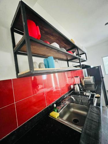 a kitchen with a sink and a red wall at Suites Maya Ka’an in Cancún