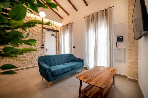 a living room with a blue couch and a wooden table at Apartamentos Loliqui centro Alicante in Alicante