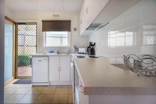 a kitchen with white cabinets and a counter top at Argo Sands in Rosebud