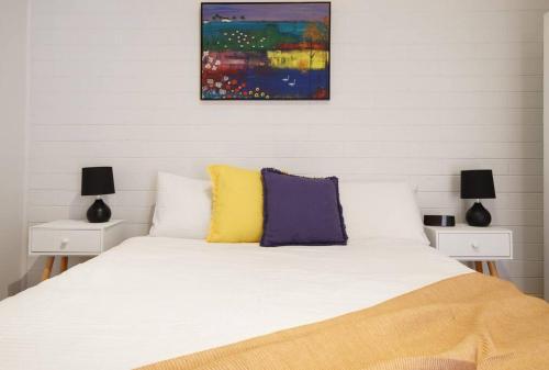 um quarto com uma cama branca com duas mesas de cabeceira em Argo Sands em Rosebud