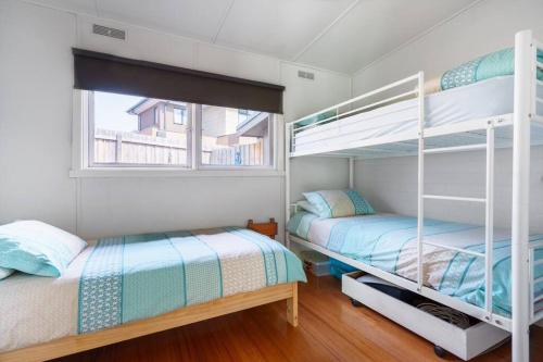 a bedroom with two bunk beds and a window at Argo Sands in Rosebud