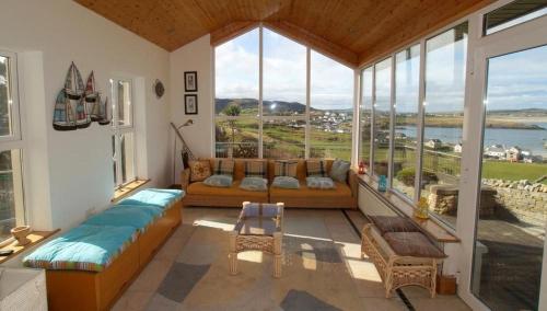 - un salon avec un canapé et une grande fenêtre dans l'établissement Horn Head View Dunfanaghy, à Dunfanaghy