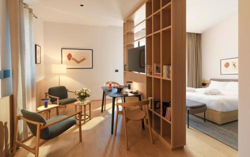ein Hotelzimmer mit einem Bett, einem Schreibtisch und einem Zimmer in der Unterkunft Le Fucine Hotel in Buttrio
