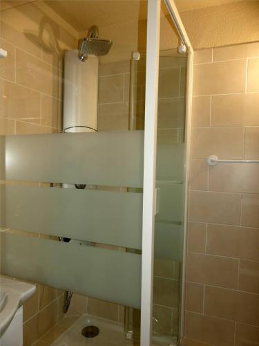 une douche avec une porte vitrée dans une salle de bain dans l'établissement Appartement au pied des pistes, à Modane