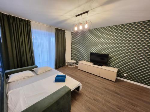 een slaapkamer met een bed en een flatscreen-tv bij Extra Class Cloud9 Apartments in Boekarest