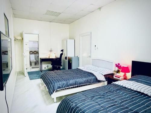 1 dormitorio con 2 camas, escritorio y piano en Private 2Bedroom Villa with T&B and Kitchenette near Abu Dhabi International Airport en Abu Dabi