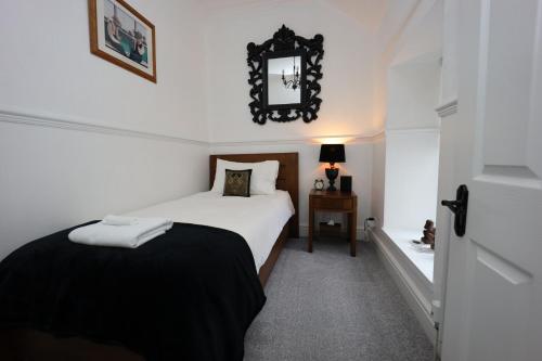 a bedroom with a bed and a mirror on the wall at Bryn Derwen in Caernarfon