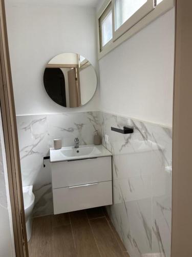 a white bathroom with a sink and a mirror at Marea in Palermo