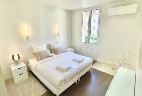 une chambre blanche avec un lit et une fenêtre dans l'établissement Arundel Croisette 100m Beach, Palais Free Parking AC Fibre, à Cannes