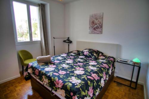 - une chambre avec un lit avec une couette à fleurs et une fenêtre dans l'établissement Ref SELV -Palmes d'Or Properties, à Cannes