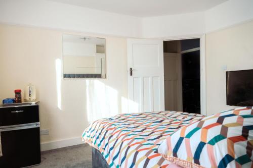 1 dormitorio con 1 cama y TV en Exclusive 26 room en Ilford