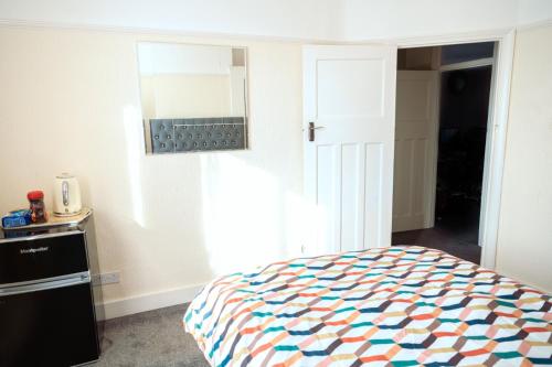 a bedroom with a bed and a mirror on the wall at Exclusive 26 room in Ilford