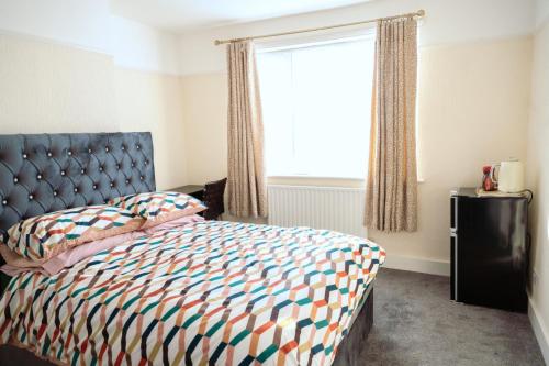 a bedroom with a bed and a window at Exclusive 26 room in Ilford