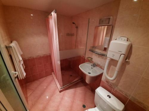 a bathroom with a shower and a toilet and a sink at Hotel Veris in Sunny Beach