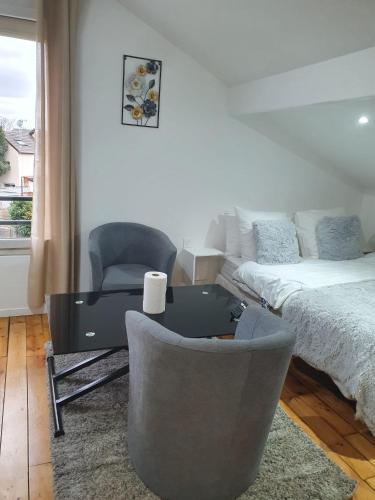 - un salon avec un bureau, un lit et une chaise dans l'établissement Studio pratique CDG/Villepinte/ le Bourget, à Aulnay-sous-Bois
